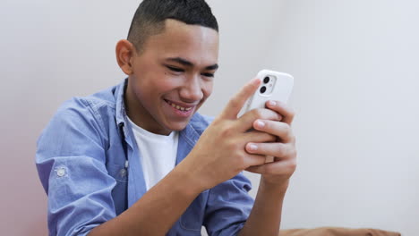 Young-boy-using-phone-on-bed