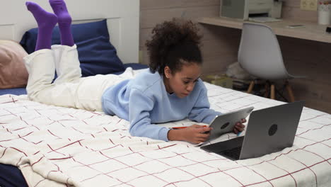 Girl-using-devices-on-bed