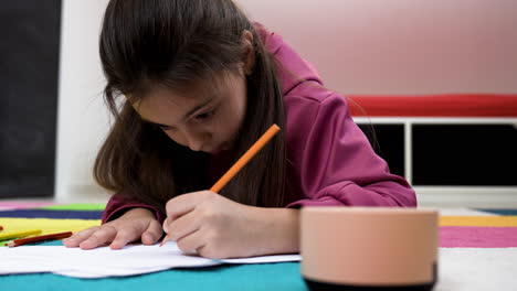 Niña-Dibujando-En-Papeles-En-Casa