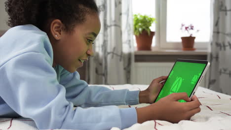 Young-girl-using-tablet-on-bed