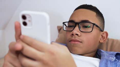 Young-boy-using-phone-on-bed