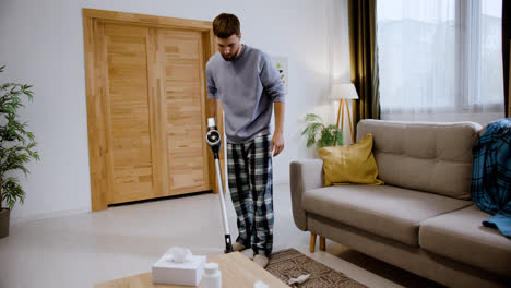 Man-using-vacuum-cleaner-in-his-living-room