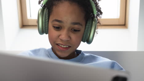 Young-girl-using-headphones-on-bed