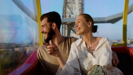 Young-couple-eating-popcorn-on-a-ferris-wheel