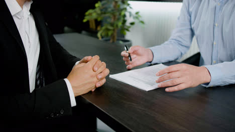 Caucasian-female-legal-advisor-hands-making-gestures-on-a-document-to-explain-a-customer-something-in-the-office