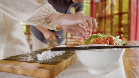 Close-up-view-of-hands-of-a-man-cutting-fresh-fish-on-top-of-a-kitchen-board