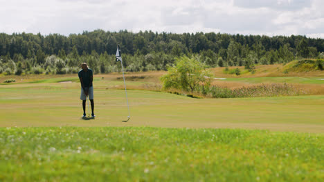 Vista-Lejana-Del-Hombre-Afroamericano-Practicando-Golf-En-El-Campo-De-Golf.