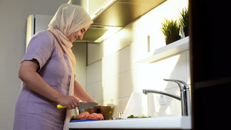 Side-view-of-woman-with-hiyab-in-the-kitchen.