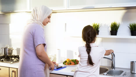 Mother-with-hiyab-and-daughter-in-the-kitchen.