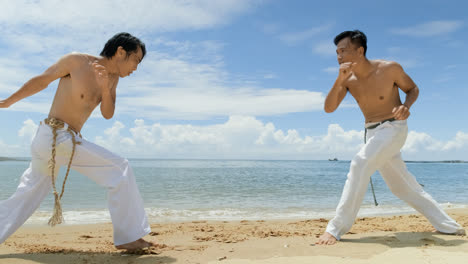 Dos-Hombres-Bailando-Capoeira-En-La-Playa