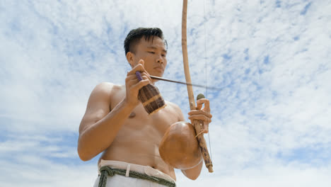 Shirtless-man-playing-instrument