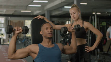Close-up-view-of-caucasian-female-monitor-and-an-athletic-african-american-man-in-the-gym.