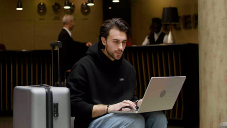 Hombre-Usando-Una-Computadora-Portátil-En-El-Hall-Del-Hotel