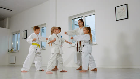Kids-in-white-kimono-and-teacher-in-martial-arts-class