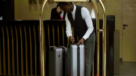Bellhop-loading-luggage-onto-a-cart-at-the-hotel