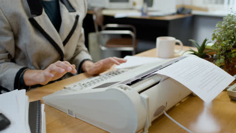 Caucasian-female-worker-typing-on-typewriter