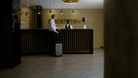 Man-receiving-his-room-key-at-the-hotel