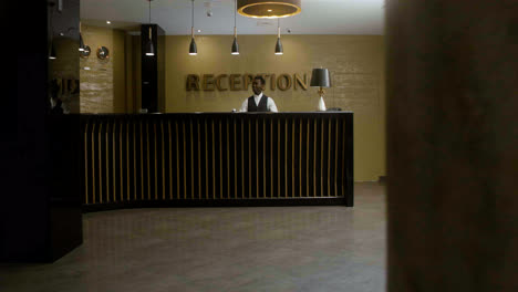 Man-approaching-the-hotel-reception-desk