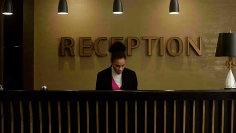 Receptionist-working-at-the-hotel-reception-desk