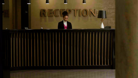 Man-receiving-his-room-key-at-the-hotel-reception-desk