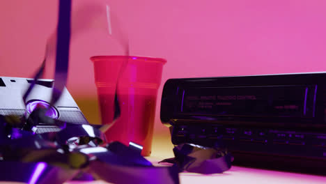 Close-up-view-of-video-VHS-device-and-cassette-on-pink-background