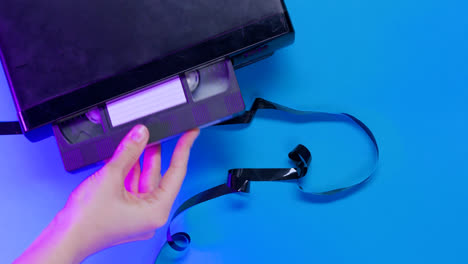 Top-view-of-video-VHS-device-and-tape-on-blue-background