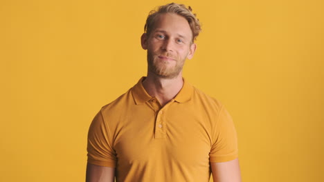 Glücklicher-Mann-Winkt-Mit-Der-Hand-Im-Gelben-Polo-T-Shirt