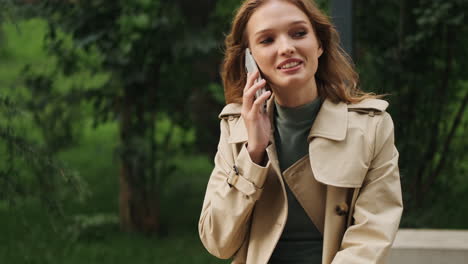 Caucasian-female-student-talking-on-the-phone-outdoors.