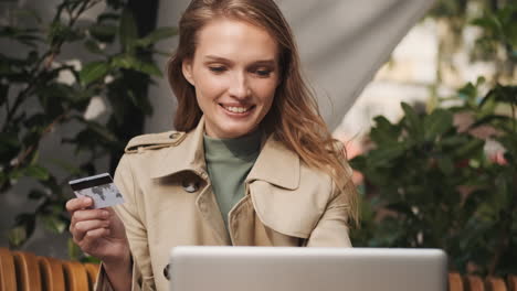 Caucasian-female-student-online-shopping-on-laptop-outdoors.