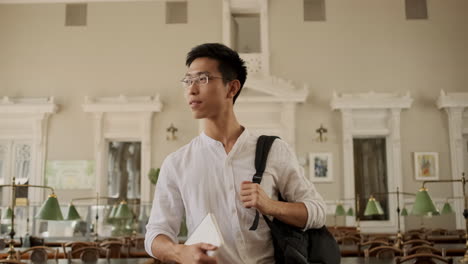 Junger-Asiatischer-Männlicher-Student,-Der-Durch-Die-Bibliothek-Geht