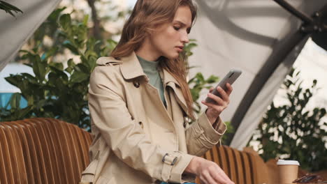 Caucasian-female-student-online-shopping-on-smartphone-outdoors.
