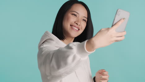Mujer-Asiática-Tomando-Selfie-En-Un-Teléfono-Inteligente.
