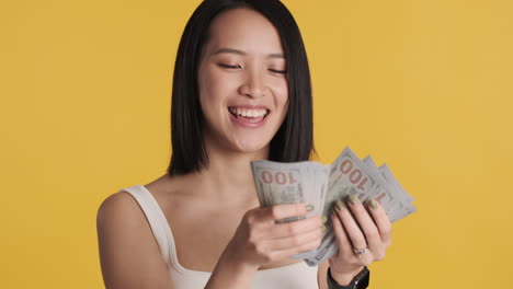 Asian-woman-counting-money-on-camera.