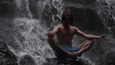 Young-man-meditating-under-waterfall.