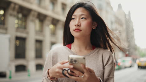 Asiatisches-Mädchen-In-Der-Innenstadt-Benutzt-Smartphone.