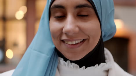 Close-up-portrait-shot-of-young-Arabian-woman-happily-looking-in-camera-outdoor.