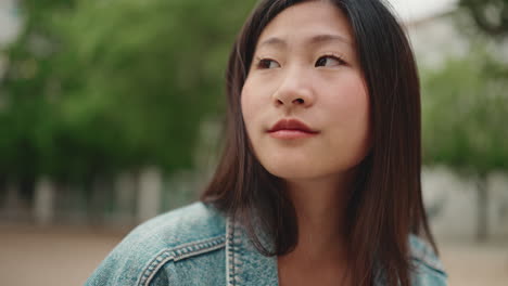 Asian-woman-with-wireless-earphones-in-the-park.