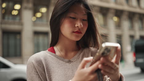 Asiatisches-Mädchen-In-Der-Innenstadt-Benutzt-Smartphone.