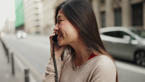 Asian-girl-talking-on-the-phone-downtown.