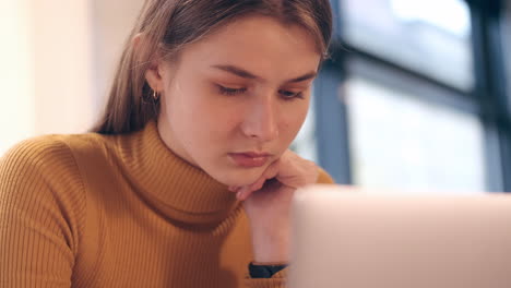 Close-up-shot-of-student-girl-confidently-studying-on-laptop-in-cafe.