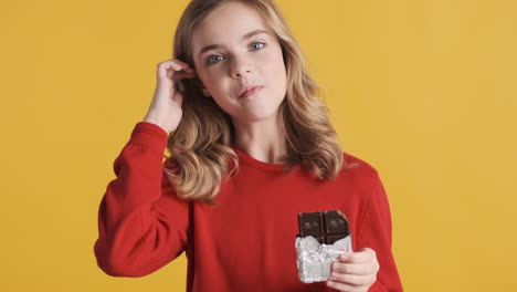 Teenage-Caucasian-girl-eating-chocolate-bar-and-smiling.