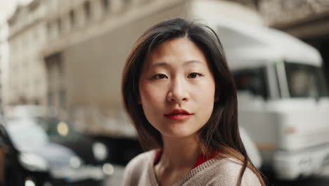 Asian-girl-smiling-at-camera-downtown.