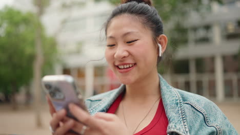 Mujer-Asiática-Con-Auriculares-Inalámbricos-En-El-Parque.