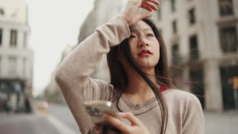 Asian-girl-with-smartphone-exploring-new-city.