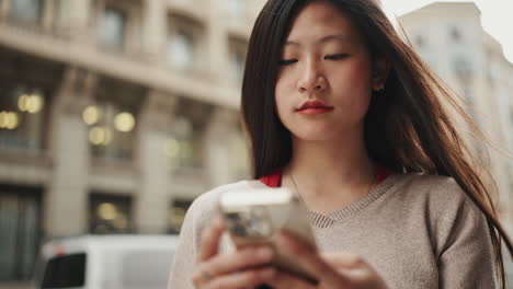 Junge-Asiatische-Frau-Benutzt-Handy-Im-Freien.