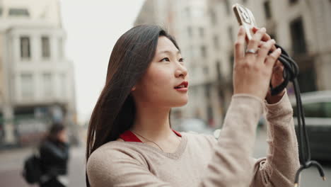 Asiatisches-Mädchen-Erkundet-Neue-Stadt-Und-Macht-Fotos-Mit-Dem-Smartphone.