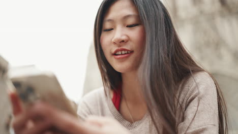 Asian-girl-texting-on-smartphone-outdoors.