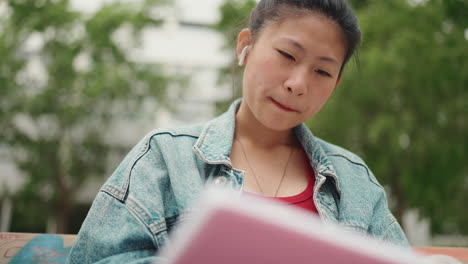 Asiatische-Frau-Schreibt-Im-Park-In-Ein-Notizbuch.