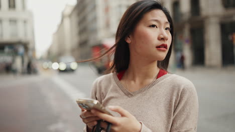 Asiatisches-Mädchen-Mit-Smartphone-Erkundet-Neue-Stadt.