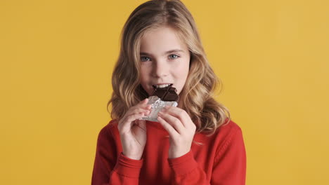 Teenage-Caucasian-girl-eating-chocolate-bar.